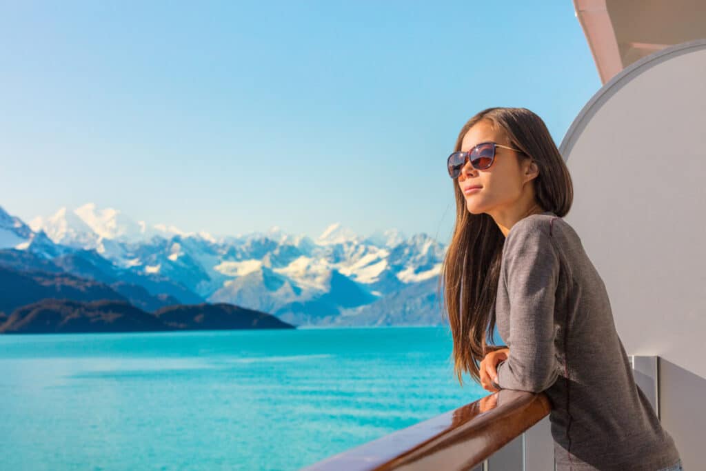 Woman on Alaskan cruise looking at mountains and the ocean